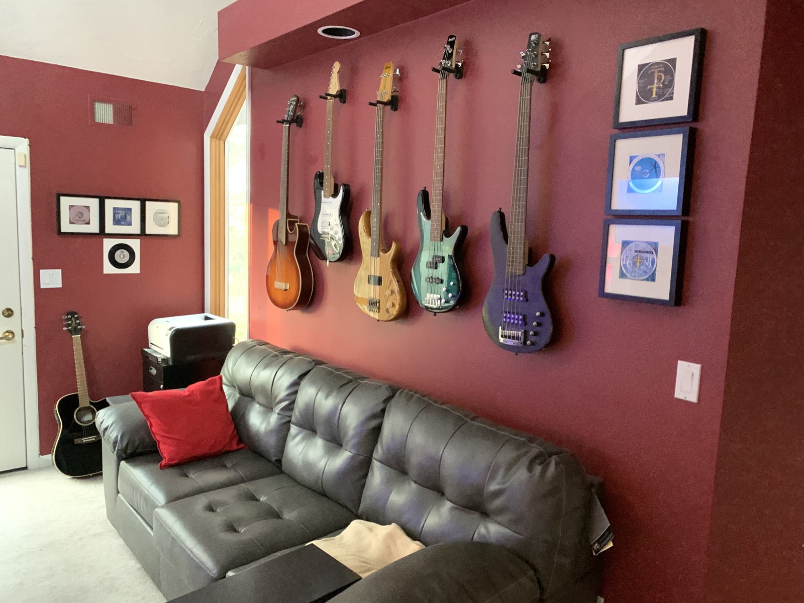 Guitars and basses hanging above a sofa at SodaPop House