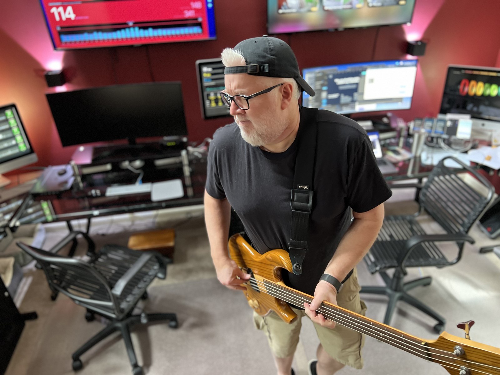 Scotto playing bass guitar in the SodaPop House control room